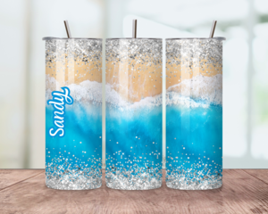 Sandy beach and water tumbler shown on all sides, featuring soft beige sand and gentle blue ocean waves wrapping the design.
